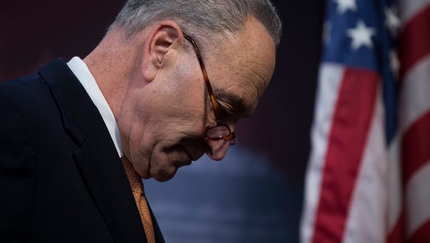 Senate Minority Leader Chuck Schumer walks from...
