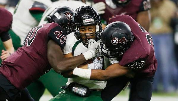 FILE - In this file photo made Friday, Dec. 18, 2015, Mansfield Lake Ridge running back Joseph Rowe (44) is tackled by Richmond George Ranch's Toby Ndukwe (40) and Myles Thompson (22) during the Texas UIL 5A Division I state high school championship football game in Houston. Texas is set to launch what state officials call the nation's largest effort to track brain injuries among youth and high school athletes, and hopes to use the data to gauge where rules and equipment changes are improving player safety. (AP Photo/Bob Levey, File)