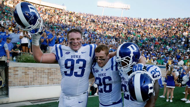 Duke defensive tackle A.J. Wolf, left, Corbin McCarthy (26) and Jela Duncan celebrate their win over Notre Dame.