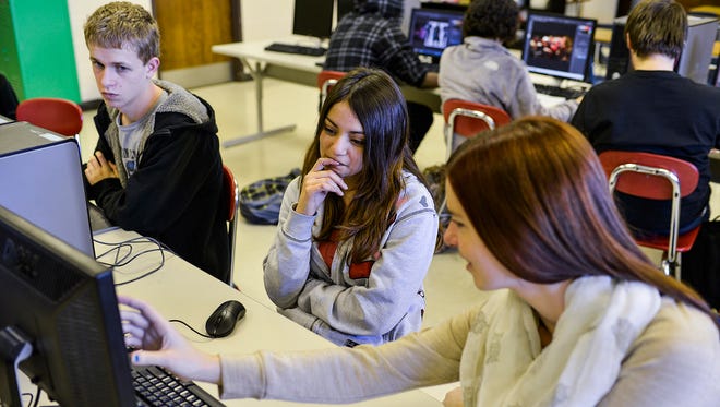 Gisela Retz, 16, center, gets feedback on her Photoshop project from Jangle Mayfield, 17, while Thomas Ownes, 16, looks on during the game design class at the Arvin Education Center in Oldham County. This is the first year of the game design program.