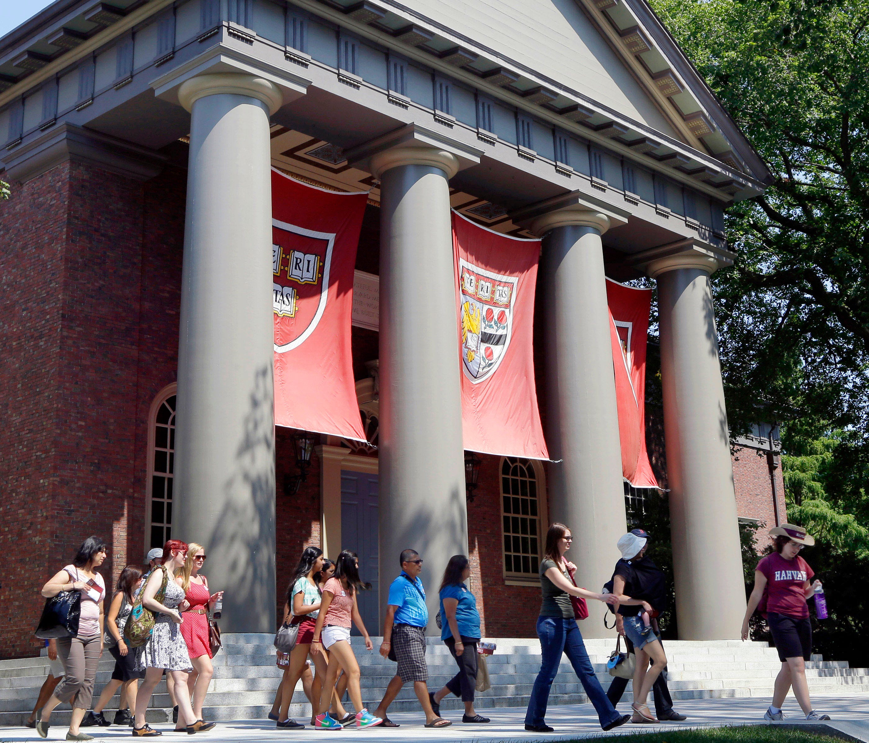 FILE - In this Aug. 30, 2012, file photo, a tour group walks through the campus of Harvard University in Cambridge, Mass. Word of an August 2017 Justice Department inquiry into how race factors into admissions at Harvard University has left top-tier 