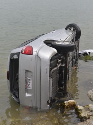 The vehicle, flipped on its side, in Lake Michigan.