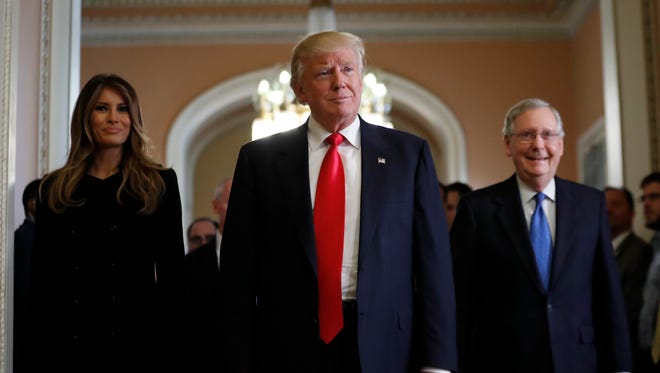 President-elect Donald Trump and his wife Melania walk with Senate Majority Leader Mitch McConnell of Kentucky on Capitol Hill on Thursday.