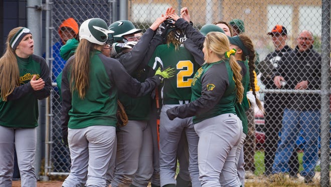 Pennfield's softball team cheers around Alexa Stephenson after hitting a home run during their All-City Tournament championship against Harper Creek on Saturday morning.