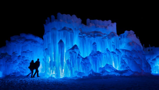A couple heads toward an entrance to a cavern at Ice Castles in North Woodstock, N.H.