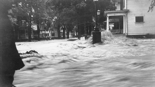 A torrent of flood water forms a rapid off a porch on North Aurora Street during Ithaca’s devastating flood in July 1935. The storm is estimated to have killed more than 100 people throughout New York state and caused $1.5 million of damage in Ithaca.