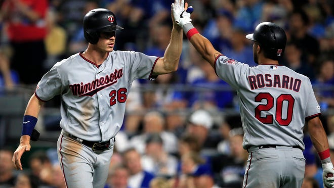 Minnesota Twins' Max Kepler (26) is congratulated by Eddie Rosario (20) after scoring during the seventh inning of the team's baseball game against the Kansas City Royals at Kauffman Stadium in Kansas City, Mo., Friday, June 21, 2019. (AP Photo/Orlin Wagner)