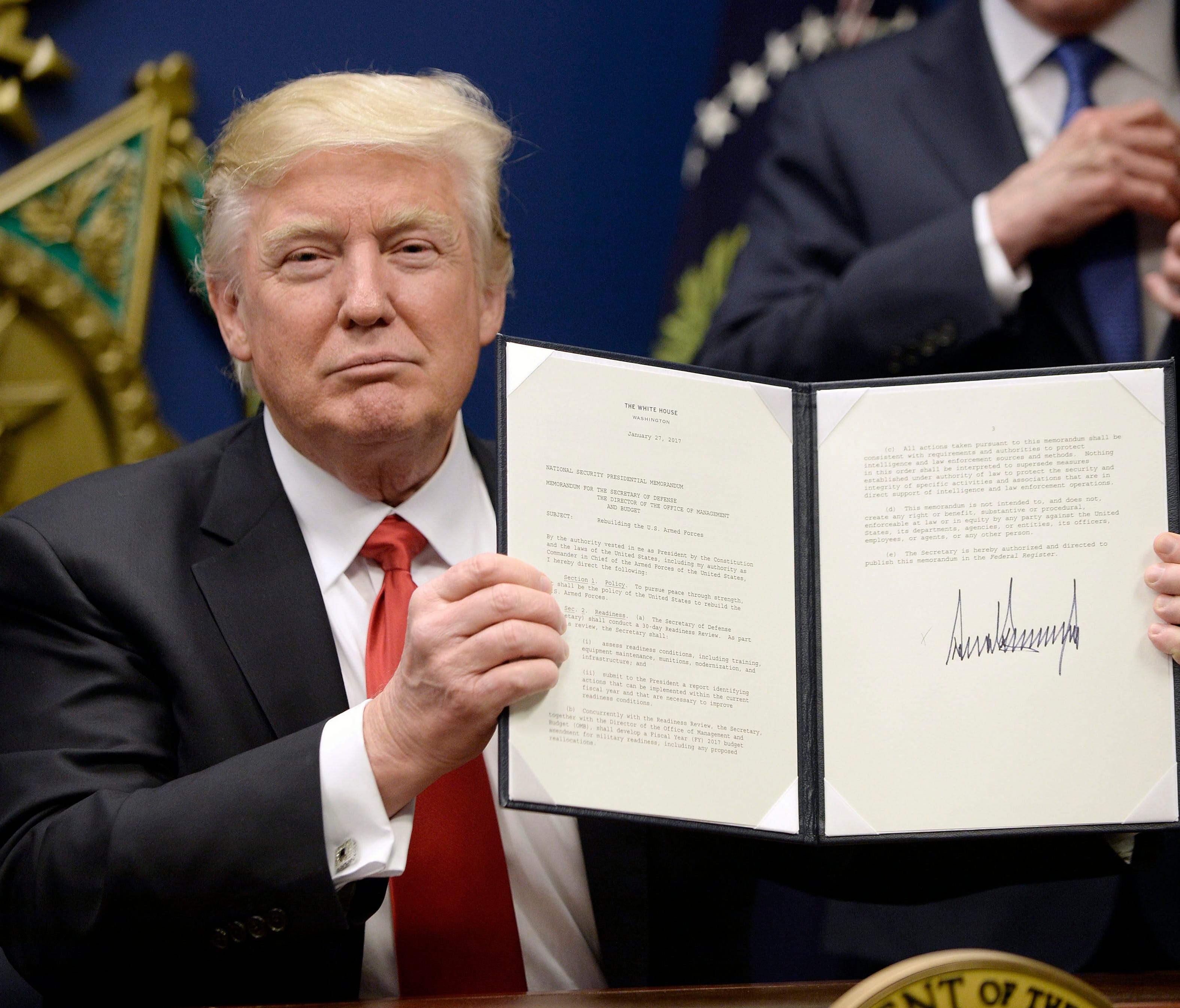 President Trump signs executive orders, including a temporary travel ban against people from seven majority-Muslim countries, at the Pentagon in Arlington, Va., on Jan. 27, 2017.