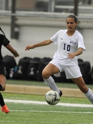 Wylie's Randie Dennison (right) runs the ball down the field while guarded by Kennedale's Alondra Olmos (left) during the first half of the Lady Bulldogs' 4-0 loss in the Region I-4A championship game on Saturday, April 9, 2016, at Wildcat Stadium in Kennedale.