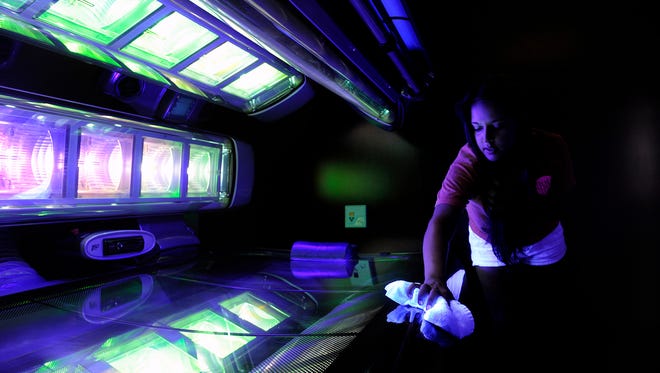Hot Spot Tanning employee Tiffany Brown cleans a tanning bed at the Brentwood, Tenn., business on Aug. 14.