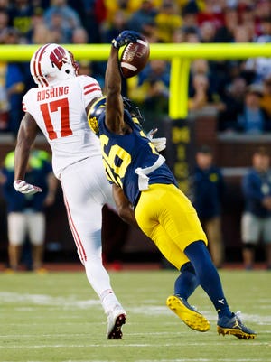 Michigan cornerback Jourdan Lewis (26) intercepts a pass intended for Wisconsin wide receiver George Rushing (17) in the fourth quarter of the Wolverines' 14-7 victory at Michigan Stadium.