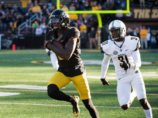 Missouri wide receiver J'Mon Moore, left, runs past