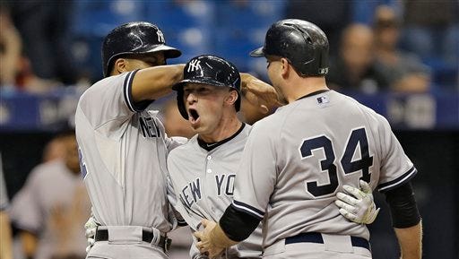 New York Yankees' Slade Heathcott, center, celebrates his three-run home run off Tampa Bay Rays relief pitcher Brad Boxberger with Chris Young, left, and Brian McCann, right, during the ninth inning of a baseball game Monday, Sept. 14, 2015, in St. Petersburg, Fla.