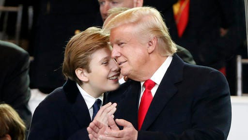 President Donald Trump, right, smiles with his son Barron as they view the 58th Presidential Inauguration parade for President Donald Trump in Washington. Friday, Jan. 20, 2017.