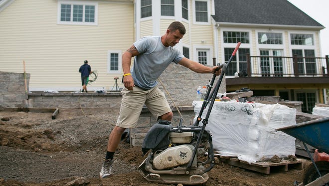 Landscaper Jesse Graham works at a home in Pittsford on Tuesday, October 6, 2015.
