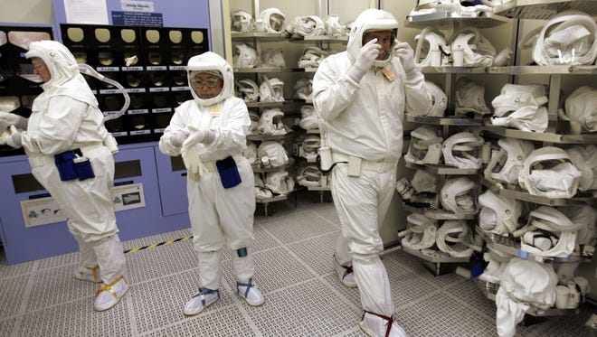 Intel Corp. workers put on clean suits before working on chip manufacturing at Intel.