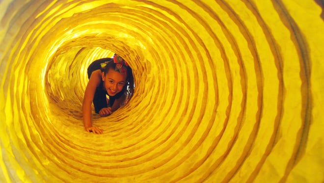 Courtney Webb, 8, navigates her way through a tunnel used for a K-9 obstacle course while attending the eighth annual Peace Day in the Park at Jaycee Park in Cape Coral last year. The festival is among this weekend's family-friendly events.