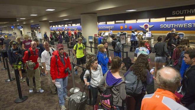 A line of travelers form outside the Southwest ticketing booths on the Sunday before Thanksgiving 2014 at Phoenix Sky Harbor International Airport.