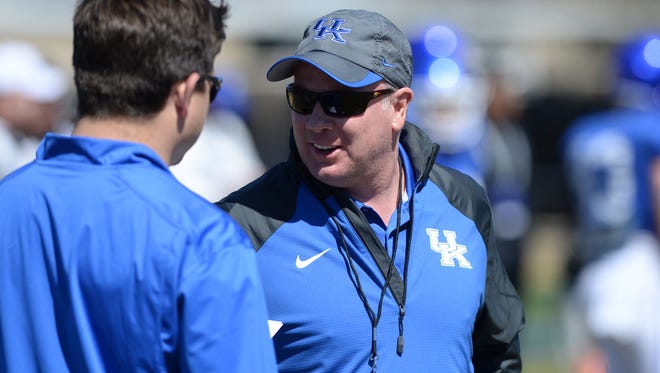 Kentucky head coach Mark Stoops talks with offensive coordinator Shannon Dawson during the Kentucky football scrimmage on Saturday, April 11, 2015.