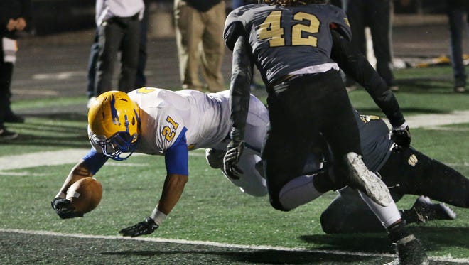 Carmel's Chris Perkins scores the Greyhounds' second unanswered touchdown in the first quarter past Warren Central's Tyan Young as the numbers 1 and 2 Class 6A teams, respectively, play on Friday, October 10, 2014. Carmel took a 14-10 lead into halftime at Warren Central.