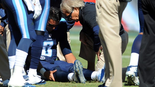 Oct 18, 2015; Nashville, TN, USA; Tennessee Titans quarterback Marcus Mariota (8) talks with team trainer Burton Elrod after an injury during the first half against the Miami Dolphins at Nissan Stadium. Mandatory Credit: Christopher Hanewinckel-USA TODAY Sports