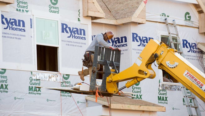This November 20, 2014 file photo shows a worker as he assists in the building of a new home in Ashburn, Virginia.