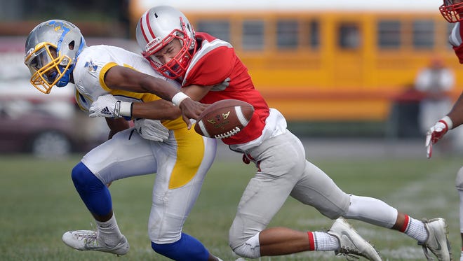 Canandaigua's Mitchell Pfeiffer, right, hits Irondequoit quarterback Fredrick June as they chase a loose fumble that was eventually recovered by Canandaigua during regular season game played at Canandaigua's Evans Field on Saturday, Sept. 10, 2016. Canandaigua beat Irondequoit 42-21.