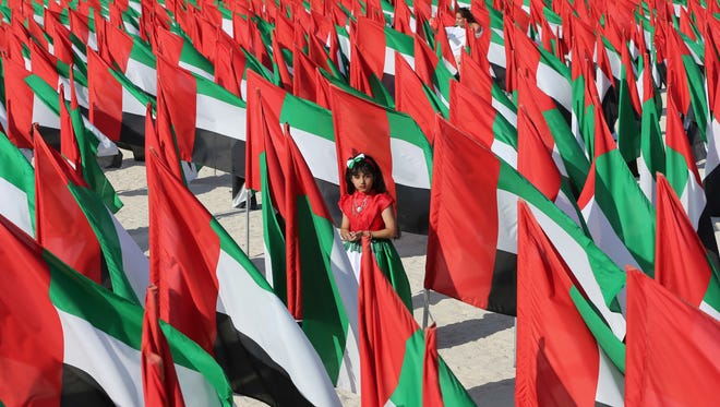 An Emirati girl walks inside the "Flags Garden" features 4000 UAE flags creating the shape of the country's map two days ahead of UAE National Day in Dubai, United Arab Emirates, Wednesday, Nov. 30, 2016. Missouri's economic development department is featuring trade shows in the small Persian Gulf country.