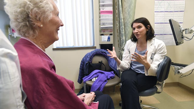 Dr. Allison Magnuson, right, speaks with patient Nancy Simpson at the Pluta Cancer Center in Rochester, N.Y.
