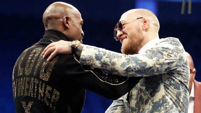 Floyd Mayweather Jr., left, and Conor McGregor embrace during a news conference after a super welterweight boxing match Sunday, Aug. 27, 2017, in Las Vegas.