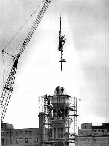 Statue of Mercury is hoisted atop the Lawyers' Co-Op
