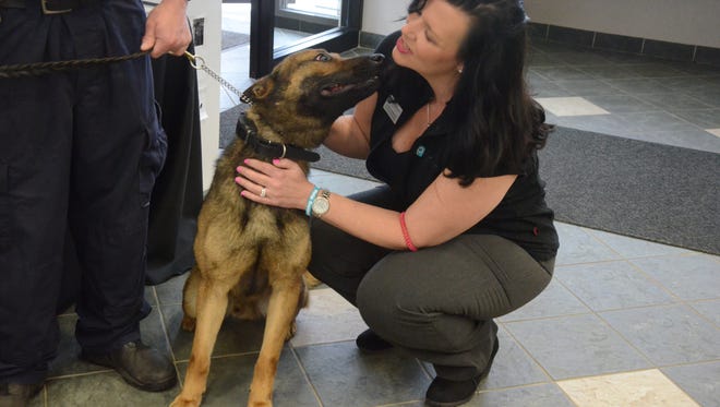 Lorrie Hammock of the Post Community Credit Union is kissed by Ace, a new police dog for the Battle Creek Police Department.