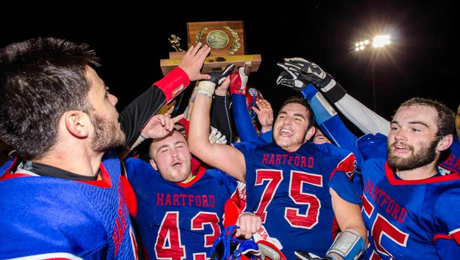 Hartford players celebrate their victory over St. Johnsbury during the Division 1 high school football state championship in Rutland on Saturday, November 12, 2016.  