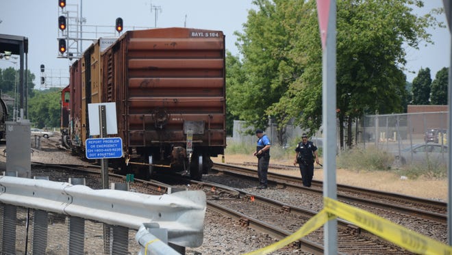 Officers walk the tracks near where a woman was killed in Battle Creek Thursday, July 12, 2018.