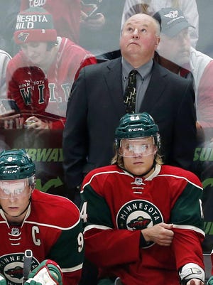 Minnesota Wild head coach Bruce Boudreau checks the scoreboard in the first period the Oct. 8 preseason hockey game in St. Paul. Boudreau will be behind the bench for the Minnesota Wild home opener on Saturday night, 40 years after he played in an arena on the same corner of downtown St. Paul for a WHA team called the Fighting Saints.