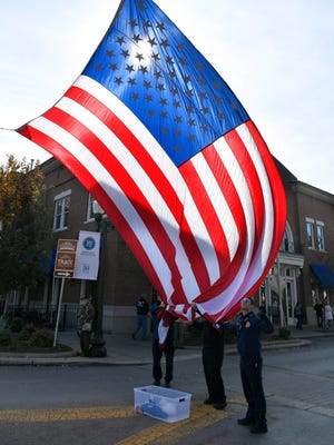 Franklin firemen lower a large American flag after the Franklin Veterans Day Parade in downtown Franklin on November 10, 2017.