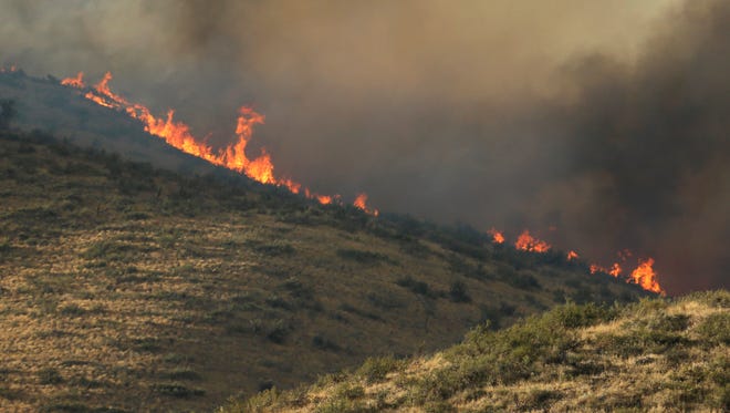 Flames and smoke rise on a hillside above Twisp River Road near Twisp, Wash., Aug. 19, 2015.