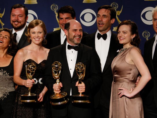 The cast and crew of 'Mad Men' pose at the 61st annual Primetime Emmy Awards. In the center holding trophies are Kater Gordon and Matthew Weiner.