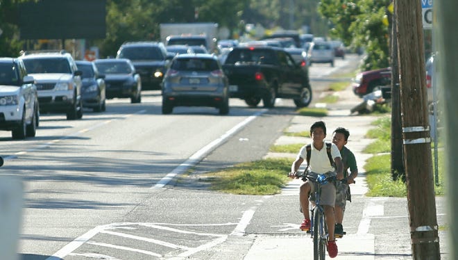School children ride their bikes on Terry Street in downtown Bonita Springs on Thursday, Oct. 26.