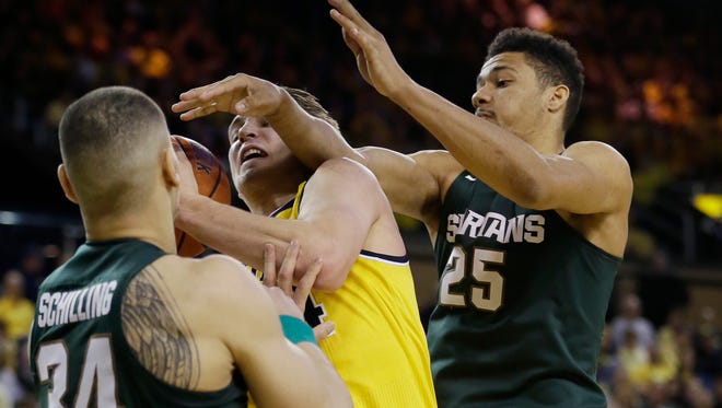 Michigan forward Mark Donnal, center, is defended by Michigan State forwards Kenny Goins, right, and Gavin Schilling on Feb. 6, 2016, in Ann Arbor.