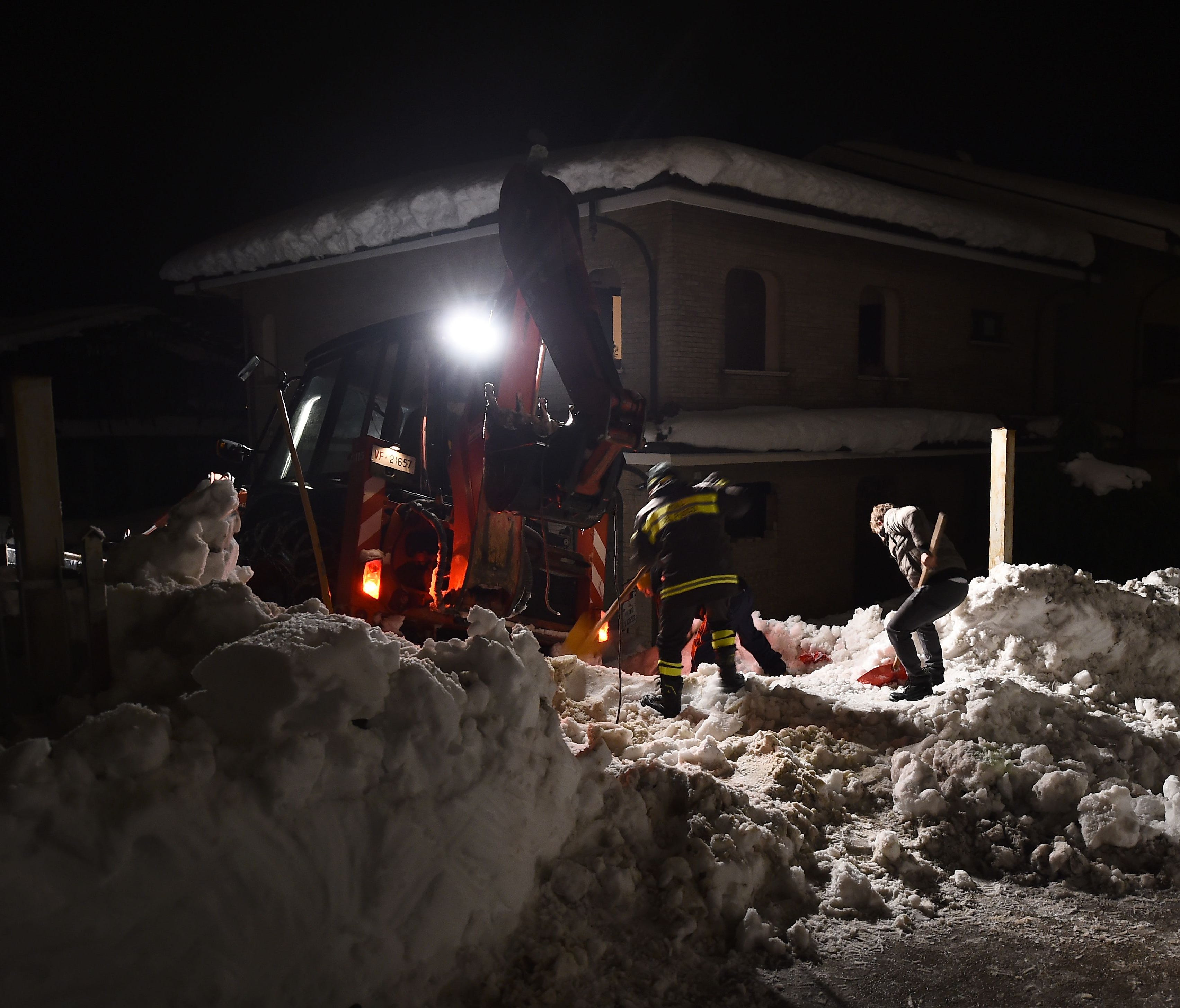 Rescuers remove snow next to a house on a road to the village of Penne, after an avalanche engulfed the mountain hotel Rigopiano in Farindola in earthquake-ravaged central Italy, on Jan. 19, 2017.