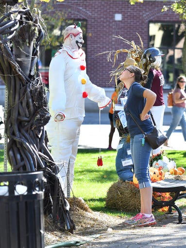 Cheryl Beadle, left, of Plymouth, checks out the scarecrow
