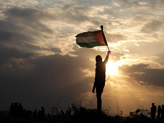 A Palestinian protester holds up a Palestinian flag