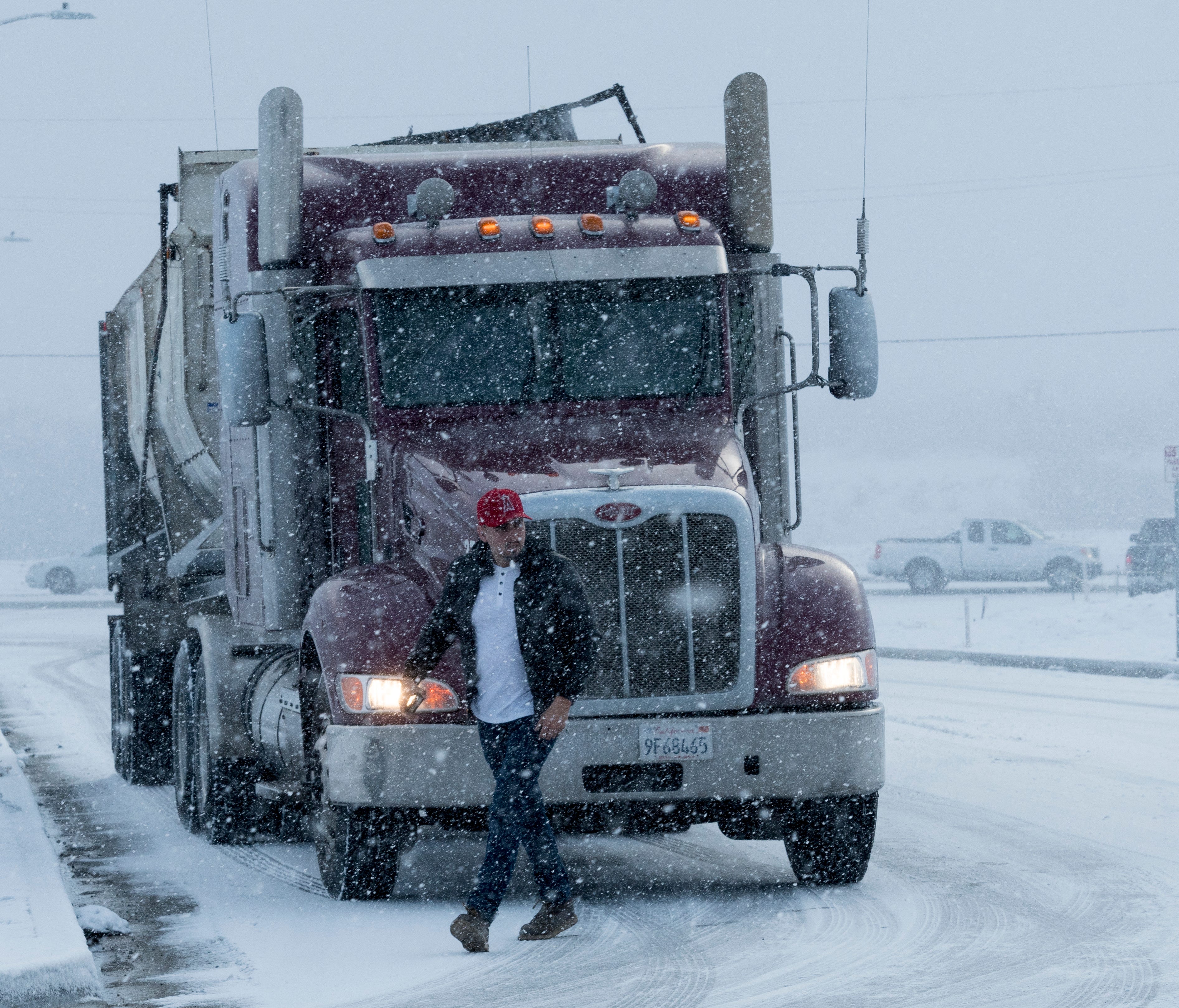 A truck driver makes his way through a snow storm which left a few inches of snow in the Cajon Pass and Oak Hills areas  in Hesperia, Calif., Tuesday Feb. 27, 2018. Many of California's mountains are sporting new coats of snow, much of it down to low
