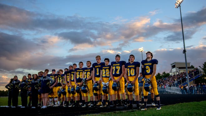 Pewamo-Westphalia's football team stands for the national anthem before the Pirates' game against Laingsburg on Friday, Sept. 29, 2017, in Westphalia.