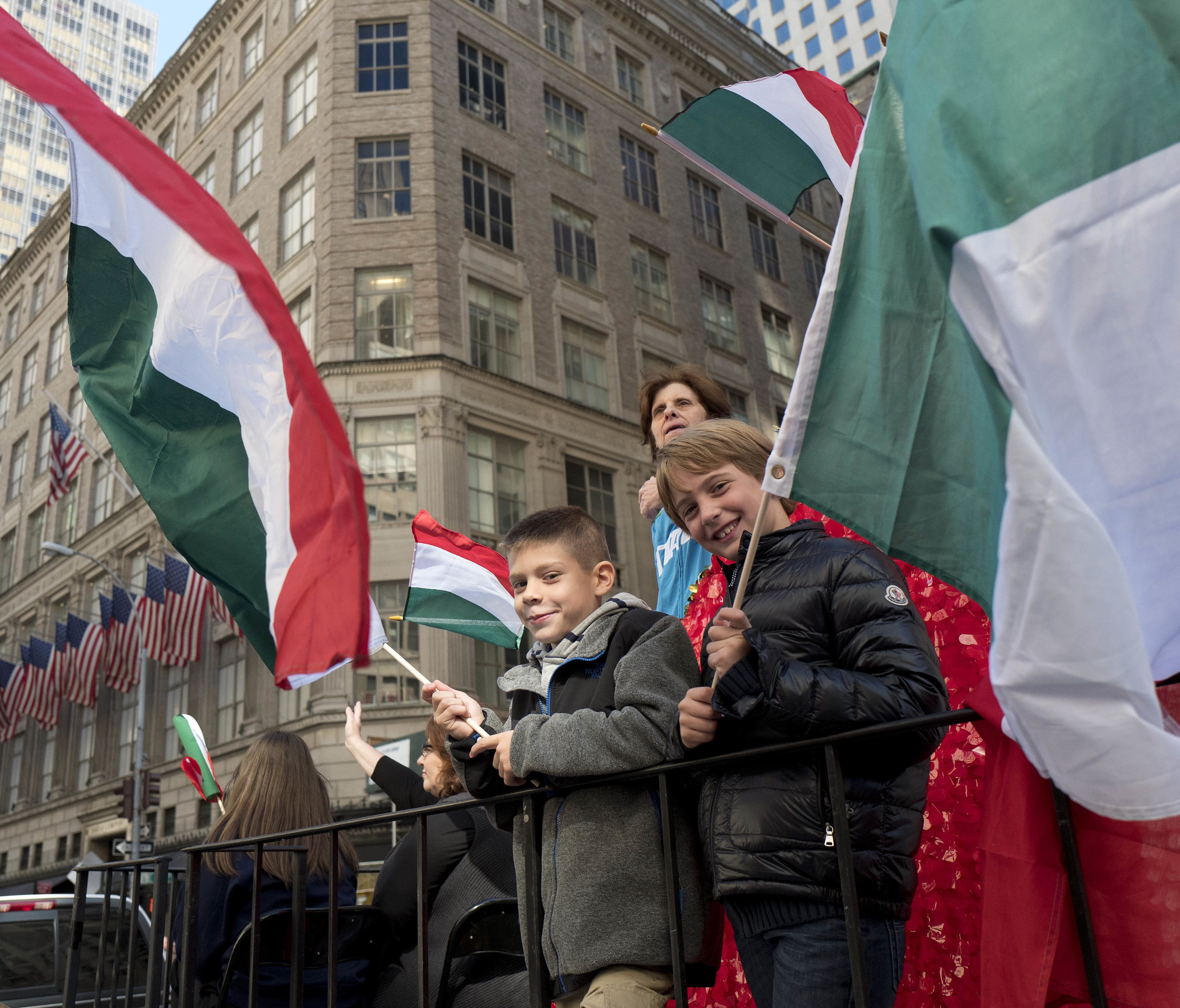 Boys wave Italian flags on Oct. 10, 2016, while riding a float in the Columbus Day Parade in New York.