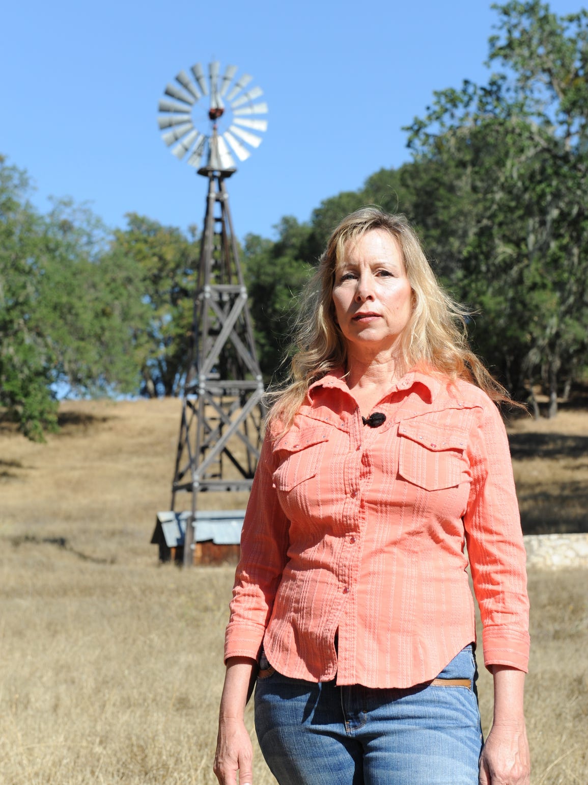 Kim Routh stands near a windmill on her ranch in San