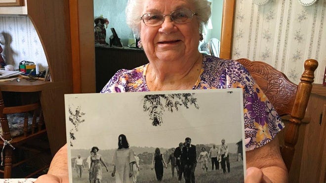 ADVANCE FOR USE SATURDAY, MAY 12 - In this April 21, 2018 photo, Ella Mae Smith, 86, of Evans City, P.a, poses with a publicity photo from the horror movie "Night of the Living Dead." In the summer of 1968, Ella Mae Smith's skin went pale, and an unholy hunger sent her shuffling through verdant fields in search of human flesh. Today, the whole world's got zombies on the brain, and for the most part, it began when the Smiths and others agreed to be in a low-budget horror film that a bunch of guys from Pittsburgh were making: Night of the Living Dead. (Jason Nark/The Philadelphia Inquirer via AP)