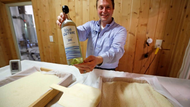 Dan Ford, founder of the Blue Current Brewery, poses with a bottle of sake at the brewery in Kittery, Maine. Steamed rice is inoculated in a sauna-like koji room for two days as part of the six week brewing process to make "rice wine."