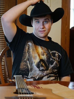Andy Bushey, 16, of Shiloh, tries on the hat given to him by his hero Garth Brooks after a concert last week.